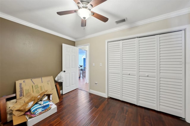 bedroom with a closet, ornamental molding, dark hardwood / wood-style floors, and ceiling fan