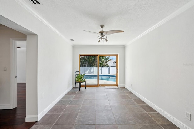 unfurnished room featuring ceiling fan, ornamental molding, and a textured ceiling