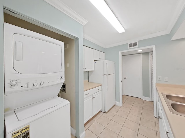 washroom featuring crown molding, stacked washer and clothes dryer, sink, and light tile patterned floors