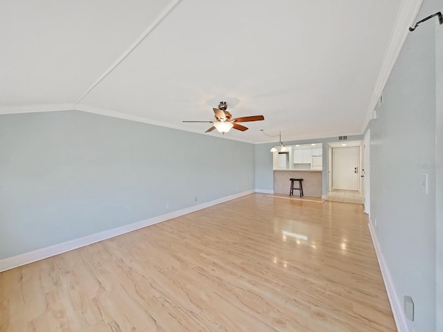 unfurnished living room featuring vaulted ceiling, ornamental molding, light hardwood / wood-style floors, and ceiling fan