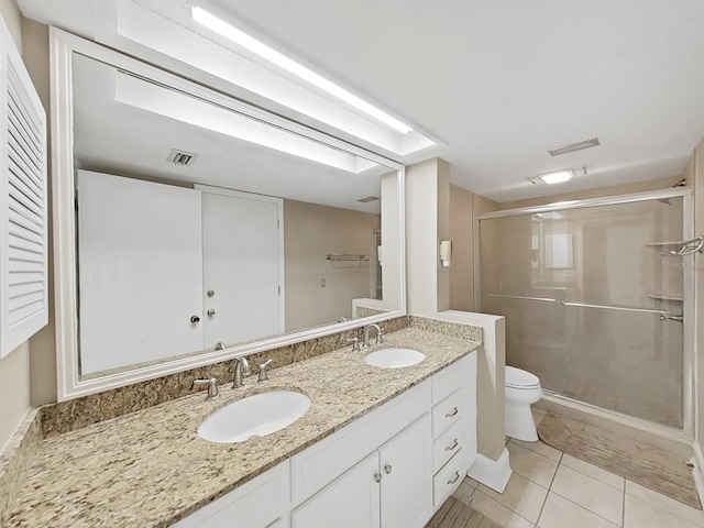 bathroom with tile patterned flooring, vanity, an enclosed shower, and toilet