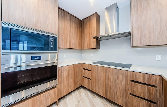 kitchen featuring stainless steel appliances and wall chimney exhaust hood