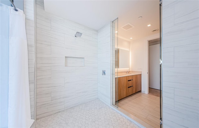 bathroom with vanity and tiled shower