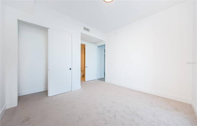 unfurnished bedroom featuring a closet and light carpet