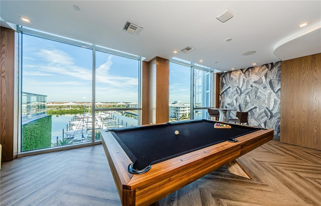 game room featuring a water view, pool table, parquet floors, and expansive windows