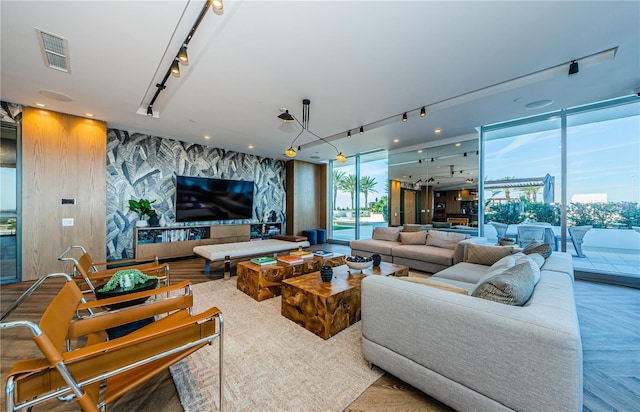 living room featuring parquet flooring, track lighting, and floor to ceiling windows