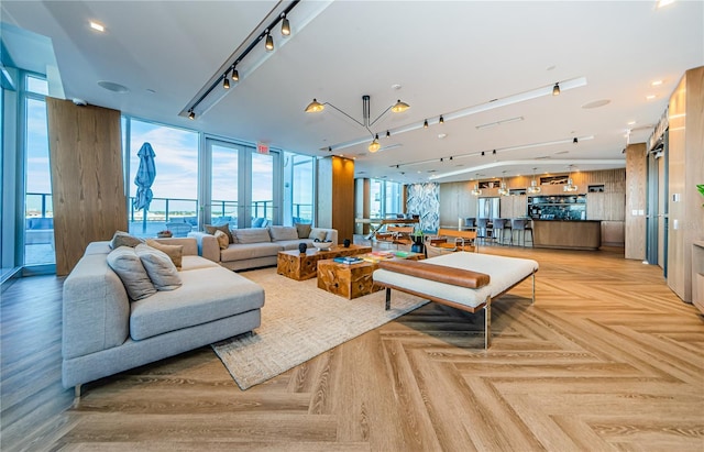 living room featuring track lighting, expansive windows, and light parquet floors