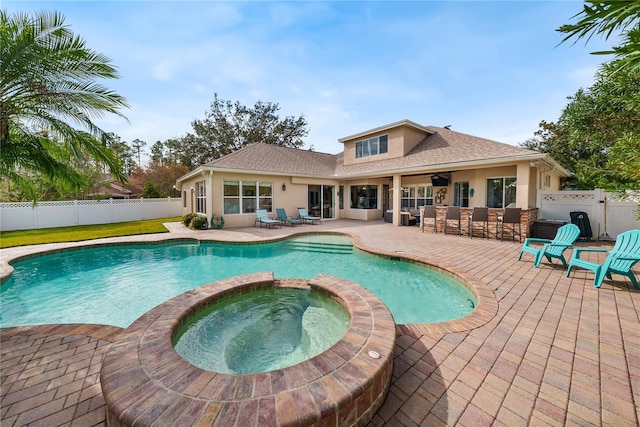 view of pool with an in ground hot tub, a bar, and a patio area