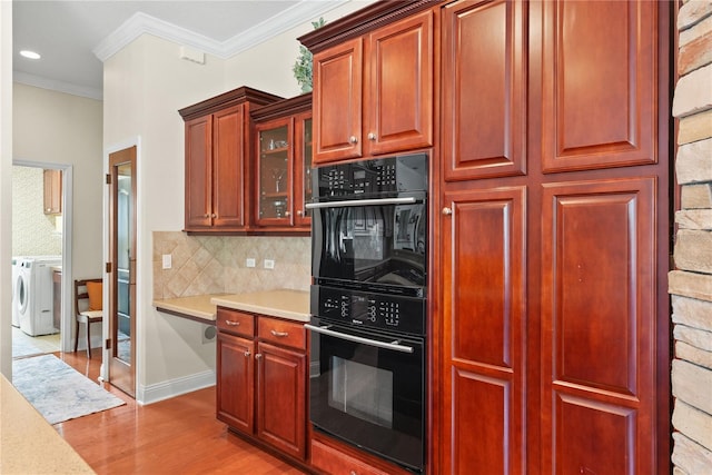 kitchen with backsplash, black double oven, ornamental molding, washer and clothes dryer, and light hardwood / wood-style flooring