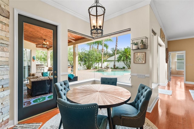 dining space featuring crown molding, an inviting chandelier, and light hardwood / wood-style floors