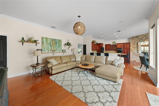 living room featuring ornamental molding and light wood-type flooring