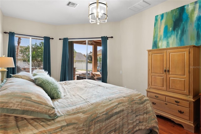 bedroom with an inviting chandelier, hardwood / wood-style floors, and access to outside