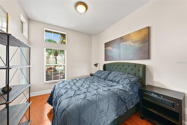 bedroom featuring hardwood / wood-style flooring and a textured ceiling