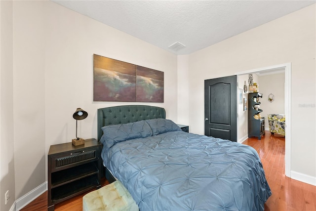 bedroom with wood-type flooring and a textured ceiling