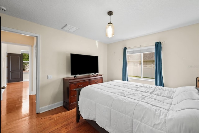 bedroom featuring hardwood / wood-style floors and a textured ceiling