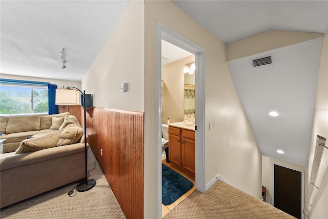 carpeted living room with rail lighting and a textured ceiling