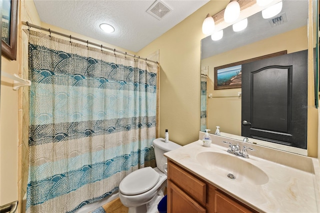 bathroom with vanity, walk in shower, a textured ceiling, and toilet