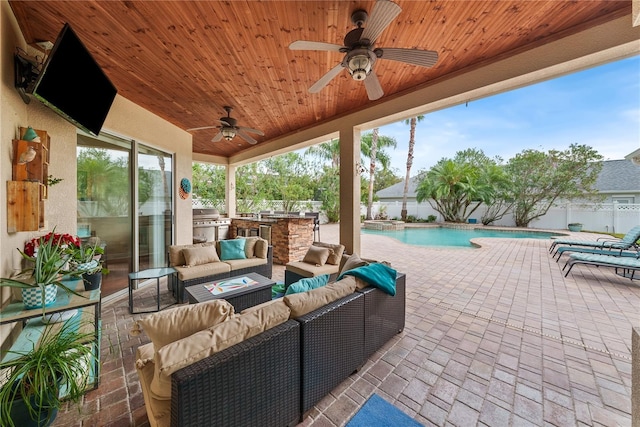 view of patio with a fenced in pool, ceiling fan, an outdoor living space, area for grilling, and exterior kitchen