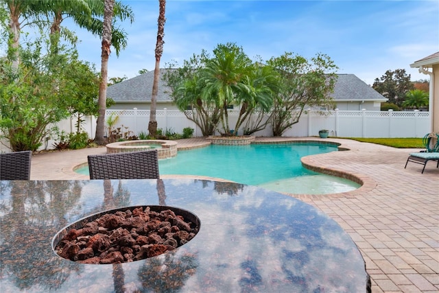 view of swimming pool featuring a fire pit, a patio area, and an in ground hot tub