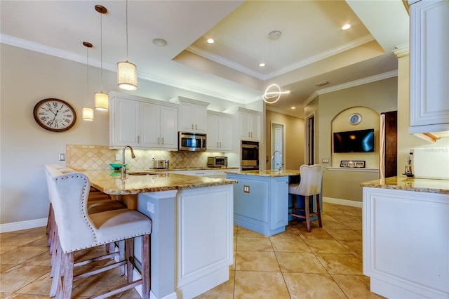 kitchen featuring stainless steel microwave, a kitchen breakfast bar, a peninsula, a tray ceiling, and a sink