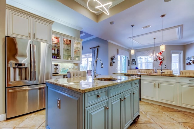 kitchen featuring stainless steel fridge, crown molding, and a sink