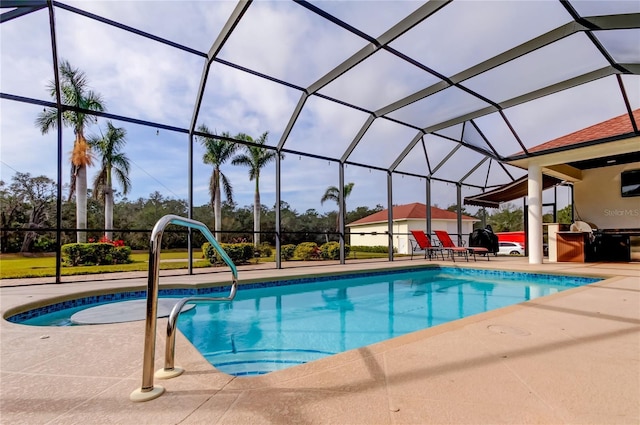 outdoor pool featuring a patio area, glass enclosure, and area for grilling