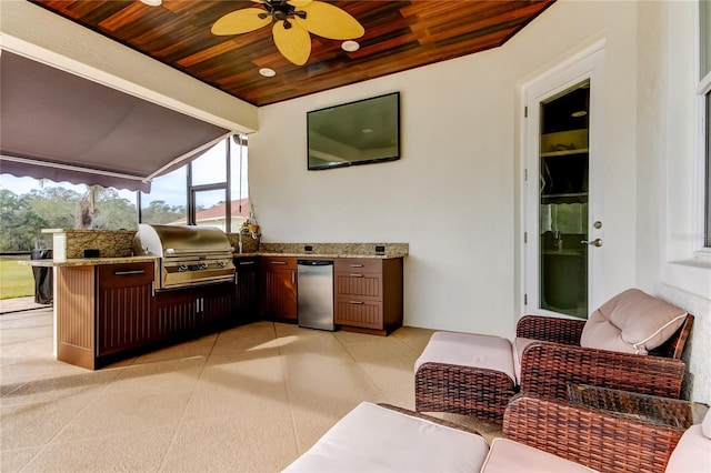 view of patio with a lanai, an outdoor kitchen, a ceiling fan, and area for grilling