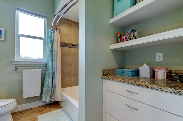 bathroom featuring shower / tub combo with curtain, toilet, vanity, baseboards, and tile patterned floors