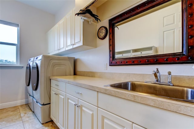 laundry room with light tile patterned floors, cabinet space, a sink, independent washer and dryer, and baseboards