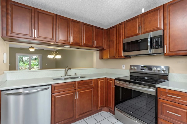 kitchen with sink, a textured ceiling, light tile patterned floors, ceiling fan, and stainless steel appliances