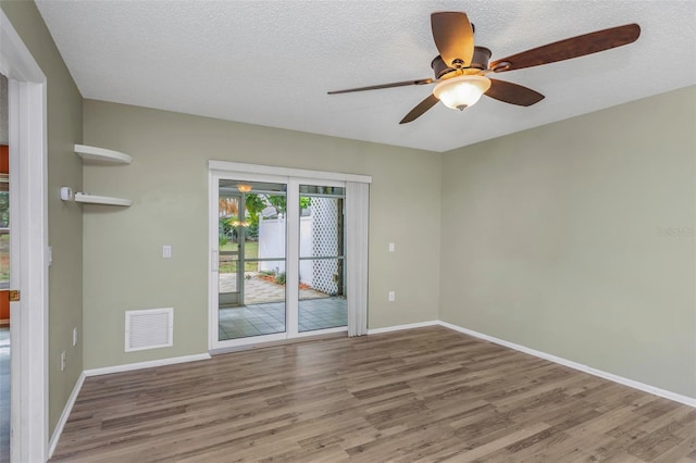 empty room with wood-type flooring and a textured ceiling