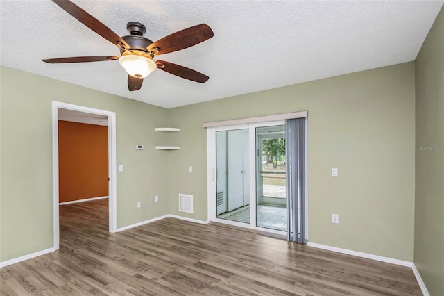 spare room with light hardwood / wood-style floors and a textured ceiling