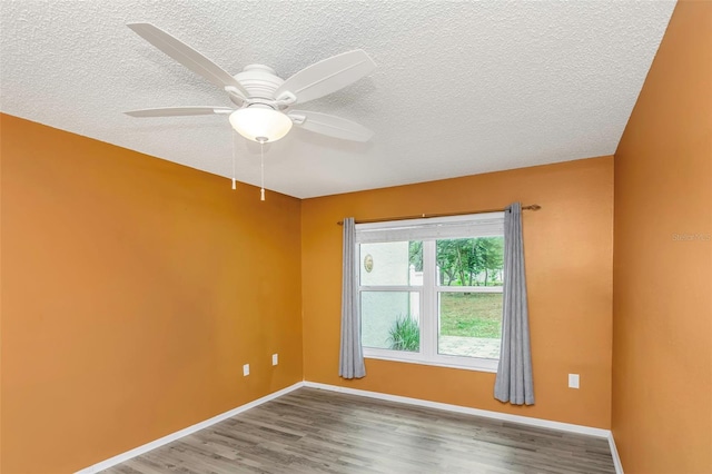 empty room featuring hardwood / wood-style flooring, a textured ceiling, and ceiling fan