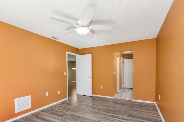 unfurnished bedroom with ceiling fan, a textured ceiling, and light wood-type flooring