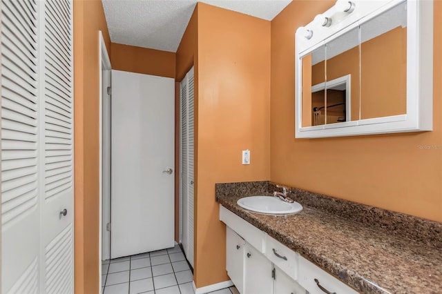 bathroom featuring tile patterned floors, vanity, and a textured ceiling