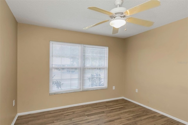 empty room with ceiling fan, wood-type flooring, and a textured ceiling