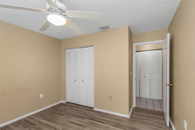 unfurnished bedroom with ceiling fan, a textured ceiling, a closet, and light hardwood / wood-style flooring