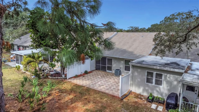 back of property featuring a lawn, a patio area, and central air condition unit