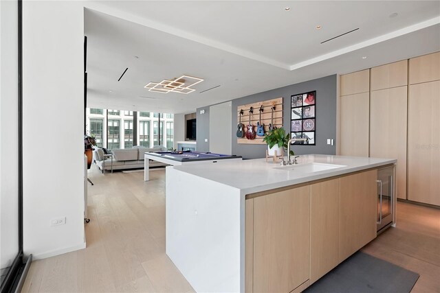 1000 Water St Unit 1002, Tampa, FL 33602 - kitchen featuring sink, floor to ceiling windows, light hardwood / wood-style floors, an island with sink, and light brown cabinetry