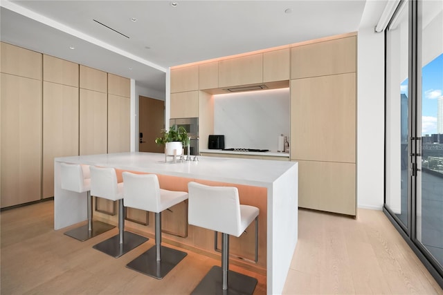 1000 Water St Unit 1002, Tampa, FL 33602 - kitchen featuring a wall of windows, a kitchen bar, light hardwood / wood-style floors, and a kitchen island