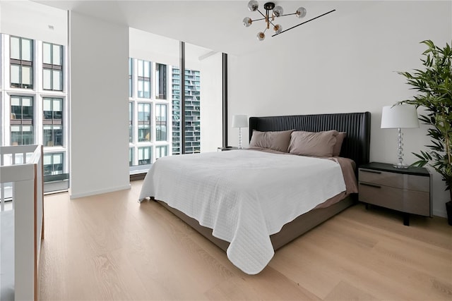 1000 Water St Unit 1002, Tampa, FL 33602 - bedroom featuring a wall of windows, a notable chandelier, and light wood-type flooring