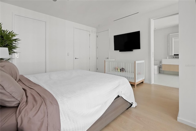 1000 Water St Unit 1002, Tampa, FL 33602 - bedroom featuring connected bathroom and light wood-type flooring