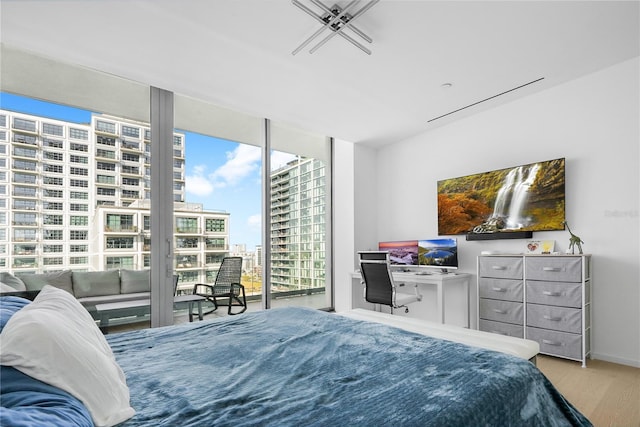 1000 Water St Unit 1002, Tampa, FL 33602 - bedroom featuring floor to ceiling windows, wood-type flooring, multiple windows, and access to outside