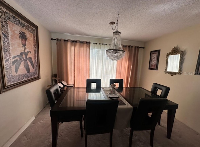 dining area with carpet flooring, a chandelier, and a textured ceiling