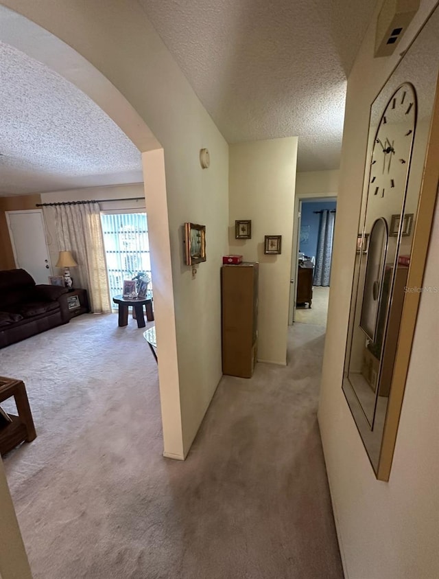 hall featuring a textured ceiling and carpet