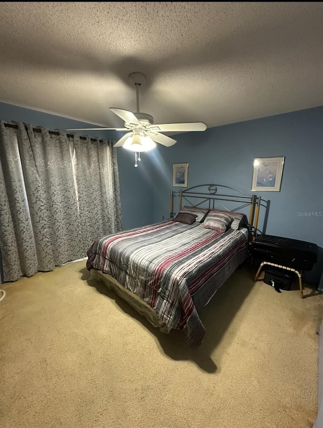 bedroom featuring ceiling fan, carpet floors, and a textured ceiling