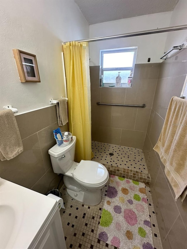 bathroom featuring tile walls, vanity, a textured ceiling, toilet, and walk in shower