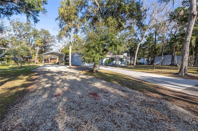 view of front of property featuring driveway, a carport, and a front lawn