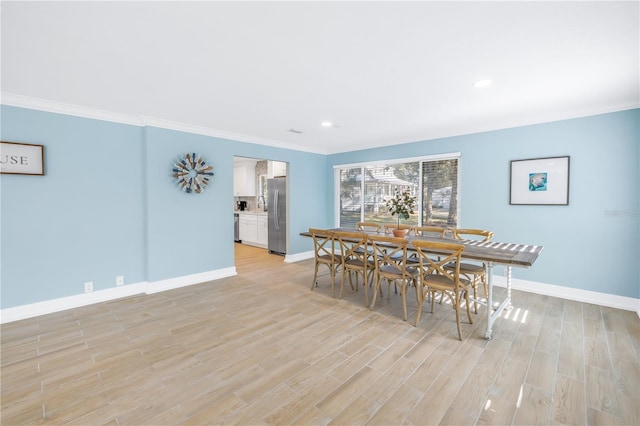 dining room with ornamental molding, recessed lighting, baseboards, and light wood finished floors