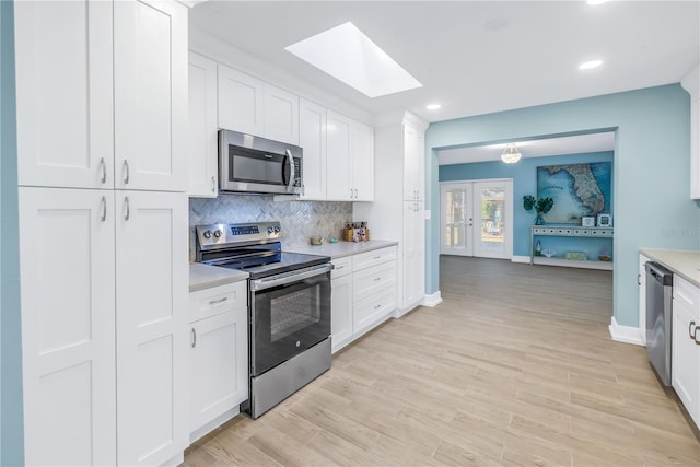 kitchen featuring stainless steel appliances, light countertops, light wood-style floors, and tasteful backsplash